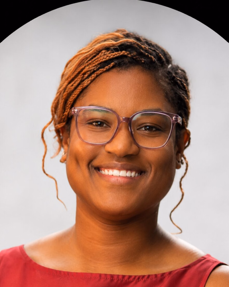 Keyana Carter, Development Manager, smiling in glasses and a red top